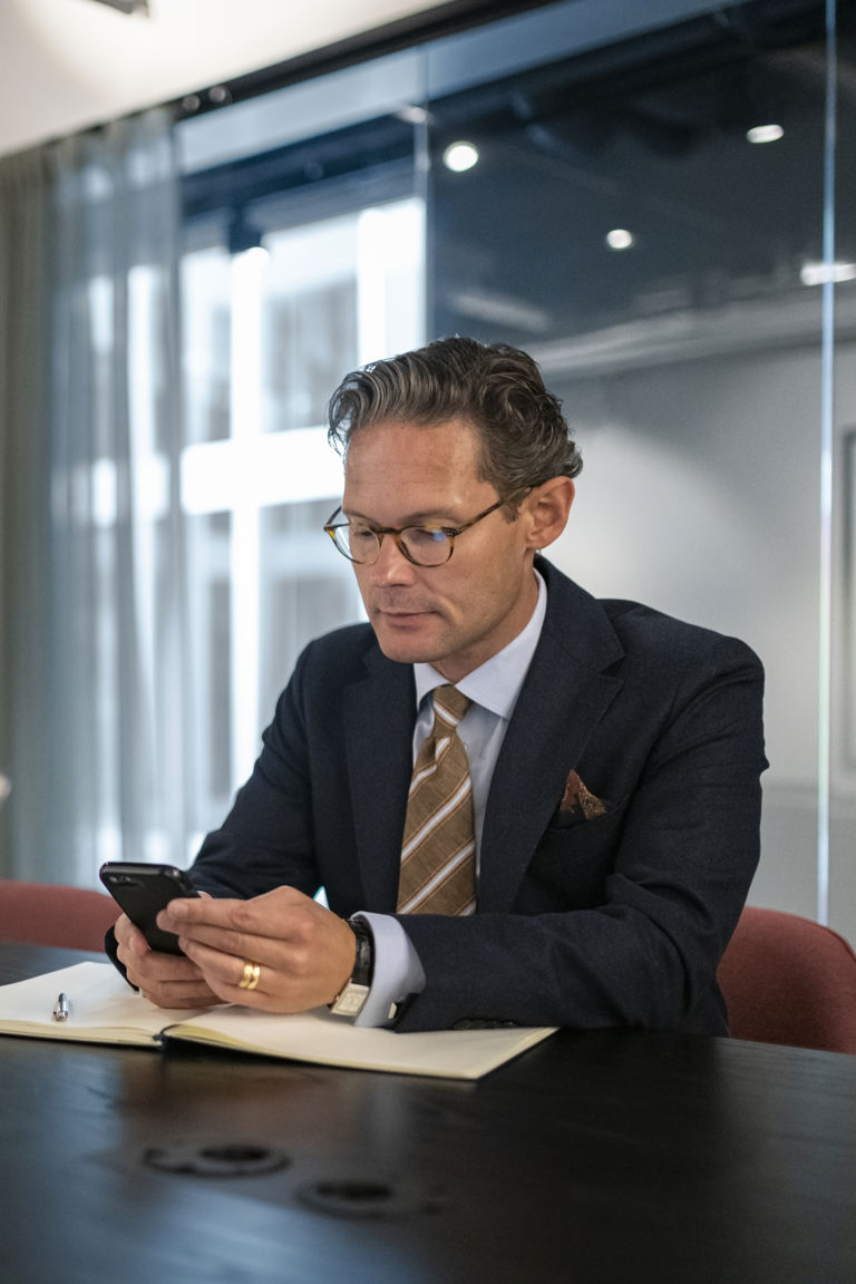 Mann sitter på telefonen i et møterom