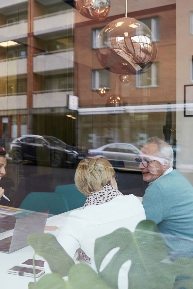 Eldre par sitter i møterom med en rådgiver